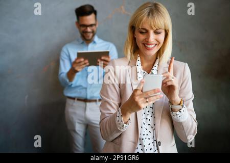 Schöne erfolgreiche Geschäftsfrau E-Mails am Telefon in modernen Büro ich zu überprüfen Stockfoto
