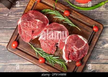 Rohes, entbeintes Rindfleisch. Rohes Rindfleisch auf einem Servierbrett aus Holz. Draufsicht Stockfoto