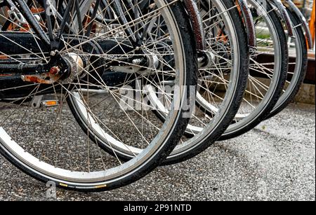 Nahaufnahmen von Fahrrädern, die an einem Regentag auf der Straße geparkt wurden - Alesund, Norwegen. 19. vom Juli 2012 Stockfoto