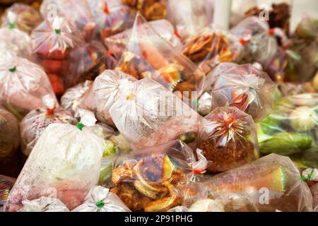 Suppen-Wagen mit exotischen asiatischen Speisen zum mitnehmen in Plastiktüten. Kreditor Garküche im Freien auf einem Bürgersteig Stockfoto