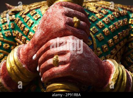 Jak Wächter Dämon Skulptur Hände Nahaufnahme in einem Thai-Tempel. Asiatische Gott bunte Statue in einem Schrein Stockfoto