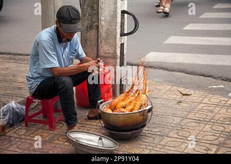 Nha Trang, Vietnam - am 30. März 2018: Street Food vendor Hummer Verkauf auf einem Bürgersteig. Im mittleren Alter asiatischer Mann Verkauf von gekochten Meeresfrüchten auf einer Seite einer Ro Stockfoto