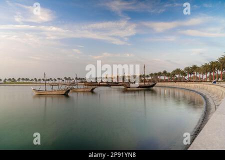 Die Skyline von Doha kann vom MIA Park aus gesehen werden und drei Dhow-Boote im Vordergrund.
