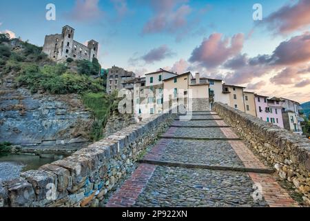 DOLCEACQUA, ITALIEN - CA. AUGUST 2020: Dolceacqua Panorama mit der antiken römischen Brücke aus Steinen und der Burg Stockfoto