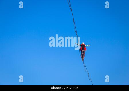 LANZO, ITALIEN - CIRCA OKTOBER 2020: Slackline-Athlet während seiner Aufführung. Konzentration, Balance und Abenteuer in diesem dynamischen Sport Stockfoto