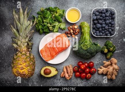 Entzündungshemmendes Diätkonzept. Eine Auswahl an Lebensmitteln, die helfen, Entzündungen zu reduzieren – pflanzliche Zutaten, frisches Obst, grünes Gemüse. Gesunde Ernährung Stockfoto