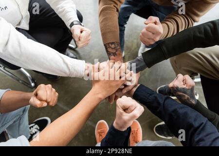Draufsicht von Menschen mit Alkoholabhängigkeit, die Hände halten und ja Geste in der Reha-Zentrum zeigen, Stock Image Stockfoto