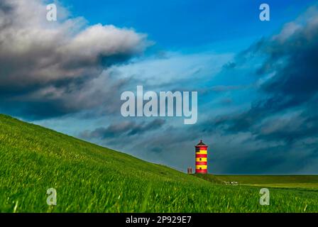 Leuchtturm Pilsum am Deich bei Greetsiel in der Region Krummhoern an der Ostfriesischen Nordseeküste, Waddenmeer-Nationalpark, Niedersachsen Stockfoto