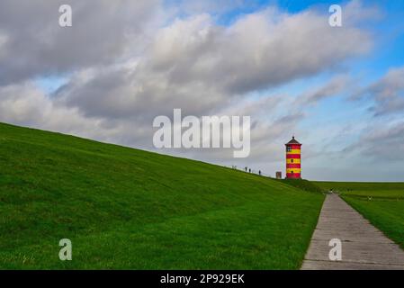 Leuchtturm Pilsum am Deich bei Greetsiel in der Region Krummhoern an der Ostfriesischen Nordseeküste, Waddenmeer-Nationalpark, Niedersachsen Stockfoto