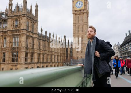 Ein Tourist steht auf einer Brücke in der Nähe des Big Ben Tower in London Stockfoto