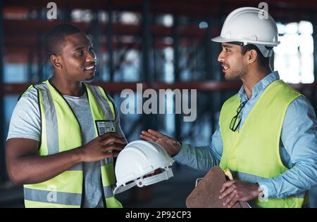 Ich will keine Probleme haben. Aufnahme von zwei jungen Fremdfirmen, die zusammen im Lager standen und eine Diskussion führen. Stockfoto