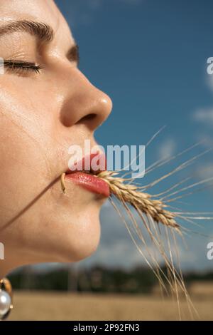 Bete für die Ukraine. Ukrainisches Mädchen auf einem Weizenfeld. Ein Mädchen auf einem Weizenfeld betet für Frieden in der Ukraine. Glückliche Frau feiert Unabhängigkeitstag Stockfoto