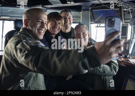 Kommandomeister Nick Wallace, links, macht ein Selfie mit Tom Cruise, Mitte links, Geschäftsführer, Captain Gregory Nery, Mitte rechts, Und kommandierender Offizier, Captain Dave Pollard, an Bord des Flugzeugträgers der Nimitz-Klasse USS George H.W. Bush, während eines Besuchs des Schiffes am 3. März 2023, während er Szenen für "Mission: Impossible - Dead Reckoning Part Two" filmte. Die George H.W. Die Bush Carrier Strike Group ist in den USA stationiert Marinestreitkräfte Europa Einsatzgebiet, angestellt von den USA Sechste Flotte, die die Interessen der USA, Verbündeten und Partner verteidigt. Foto: MC3 Samuel Wagner/USA Die Marine Stockfoto