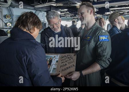 Cmdr. Brian Conlan, Navigator an Bord des Flugzeugträgers der Nimitz-Klasse USS George H. W. Bush (CVN 77), zeigt Tom Cruise während eines Besuchs des Schiffes am 3. März 2023 ein Familienfoto, während Szenen für „Mission: Impossible - Dead Reckoning Part Two“ gedreht werden. Die George H.W. Die Bush Carrier Strike Group ist in den USA stationiert Marinestreitkräfte Europa Einsatzgebiet, angestellt von den USA Sechste Flotte, die die Interessen der USA, Verbündeten und Partner verteidigt. Foto: MC3 Samuel Wagner/USA Marine/UPI Stockfoto