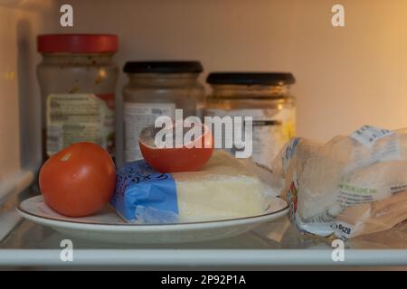 Vergessene Lebensmittel, Tomaten auf einem Teller im Kühlschrank beginnt zu verfallen, nachdem sie von einem Nadelschimmel infiziert wurden, wahrscheinlich Penicillin-Bazillen, viele reife Sporen Stockfoto