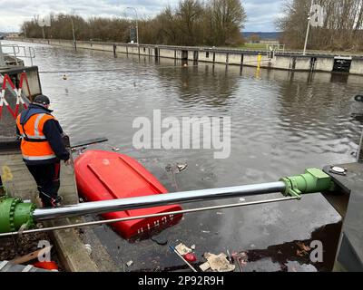 10. März 2023, Bayern, Wörth an der Donau: Ein gekentertes Boot liegt in der Geisling-Schleuse, wo zuvor ein etwa 80 Meter langes und mit Eisenerz beladenes Frachtschiff in der Donau gesunken war. Zwei Personen an Bord wurden nach ersten Berichten unverletzt, aber als Vorsichtsmaßnahme ins Krankenhaus gebracht. Die Ursache für den Untergang des Schiffes blieb zunächst unklar. Foto: Armin Weigel/dpa Stockfoto