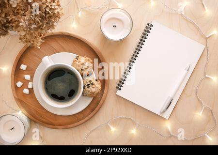 Zurück ins Leben, Zielliste-Konzept. Die Hand einer Frau schreibt in einem leeren Notizbuch auf einem Holztisch. Lösungen, Plan, Ziele, Checkliste, Ideenkonzept. Draufsicht, Stockfoto