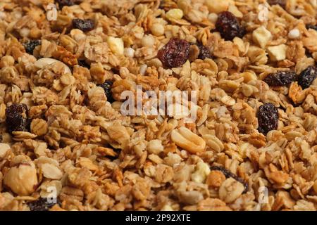 Müsli Hintergrund. Hausgemachtes Granola, Vollformat. Draufsicht, Nahaufnahme. Trockene Muesli-Mischhalde, drehbar auf Drehteller. Abstraktes Kornmuster, Stockfoto