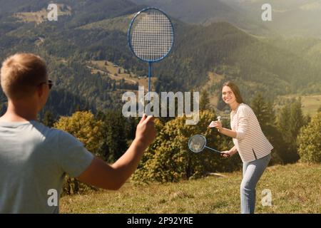 Ein Paar, das an sonnigen Tagen in den Bergen Badminton spielt Stockfoto