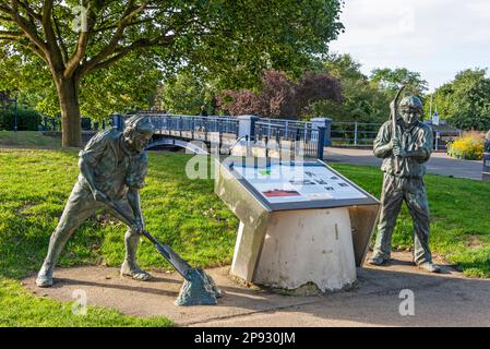 Ein Bronzemonument von zwei Grachtengräbern neben der Ladies Walk Bridge, die den Royal Military Canal in Hythe, einer Marktstadt an der Küste am Rande, überspannt Stockfoto