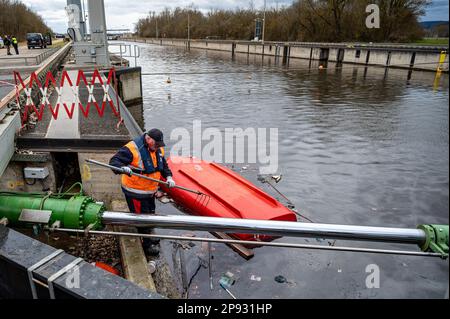 10. März 2023, Bayern, Wörth an der Donau: Ein gekentertes Boot liegt in der Geisling-Schleuse, wo zuvor ein etwa 80 Meter langes und mit Eisenerz beladenes Frachtschiff in der Donau gesunken war. Zwei Personen an Bord wurden nach ersten Berichten unverletzt, aber als Vorsichtsmaßnahme ins Krankenhaus gebracht. Die Ursache für den Untergang des Schiffes blieb zunächst unklar. Foto: Armin Weigel/dpa Stockfoto