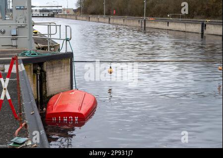 10. März 2023, Bayern, Wörth an der Donau: Ein gekentertes Boot liegt in der Geisling-Schleuse, wo zuvor ein etwa 80 Meter langes und mit Eisenerz beladenes Frachtschiff in der Donau gesunken war. Zwei Personen an Bord wurden nach ersten Berichten unverletzt, aber als Vorsichtsmaßnahme ins Krankenhaus gebracht. Die Ursache für den Untergang des Schiffes blieb zunächst unklar. Foto: Armin Weigel/dpa Stockfoto