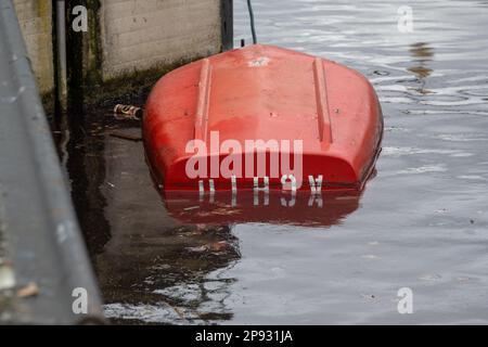 10. März 2023, Bayern, Wörth an der Donau: Ein gekentertes Boot liegt in der Geisling-Schleuse, wo zuvor ein etwa 80 Meter langes und mit Eisenerz beladenes Frachtschiff in der Donau gesunken war. Zwei Personen an Bord wurden nach ersten Berichten unverletzt, aber als Vorsichtsmaßnahme ins Krankenhaus gebracht. Die Ursache für den Untergang des Schiffes blieb zunächst unklar. Foto: Armin Weigel/dpa Stockfoto