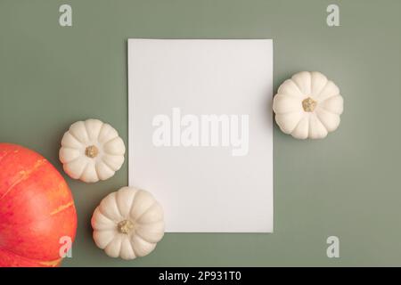 Leeres Blatt mit Halloween-Dekorationen auf pastellgrünem Hintergrund. Grußkarte, Einladungsmodell. Platz für die Beschriftung. Kürbis. Modernes Mini Stockfoto