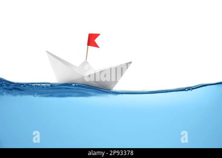 Handgemachtes Papierboot, das auf klarem Wasser vor weißem Hintergrund schwimmt Stockfoto