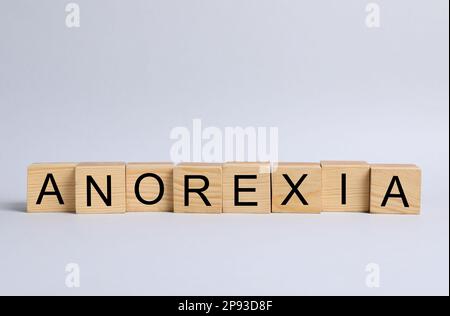 Wort Anorexia aus Holzwürfeln mit Buchstaben auf hellem Hintergrund Stockfoto