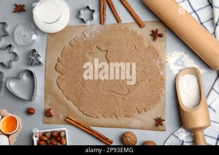 Hausgemachte Weihnachtskekse. Flache Liegezusammensetzung mit Teig und Zutaten auf hellgrauem Tisch Stockfoto