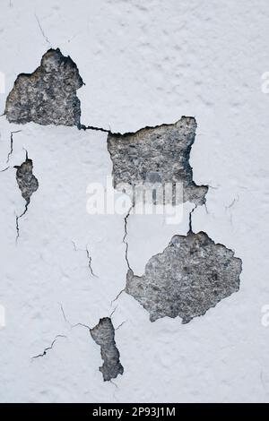 Abgesplitterte Farbe an einer grauen Wand Stockfoto