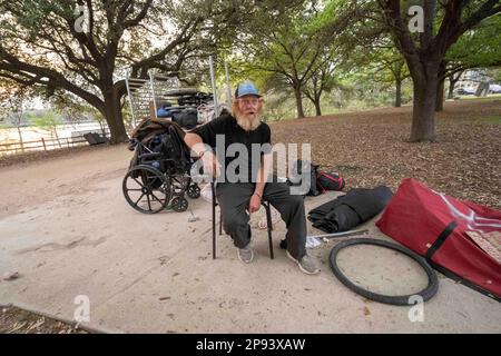 Austin, Texas, USA. 9. März 2023. Ein Obdachloser, der nicht identifiziert werden wollte, sitzt am 9. März 2023 bei den meisten seiner Sachen auf dem Wander- und Radweg entlang der Nordküste des Lady Bird Lake in der Innenstadt von Austin. Der Mann, der seit etwa 9 Monaten an der Küste zeltet, wurde schließlich von Crews gebeten, zu gehen, die einen geteilten Zaun bauen und Beleuchtung hinzufügen, nachdem er kürzlich ertrunken war. (Kreditbild: © Bob Daemmrich/ZUMA Press Wire) NUR REDAKTIONELLE VERWENDUNG! Nicht für den kommerziellen GEBRAUCH! Stockfoto