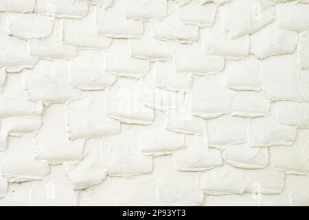 Betonputz, der ein Muster an der Wand eines alten Tonstückenhauses erzeugt Stockfoto
