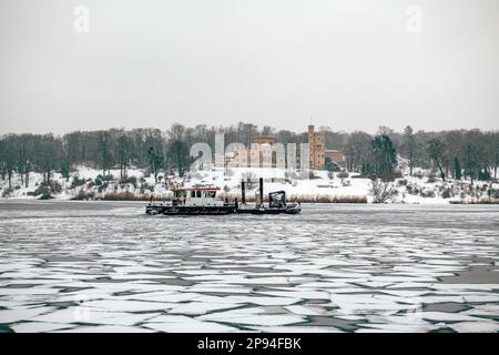 Deutschland, Brandenburg, Potsdam, Blick auf die Burg Babelsberg von der Glienicke-Brücke im Winter mit Havel-Fluss eingefroren und Eisbrecher im Vordergrund Stockfoto