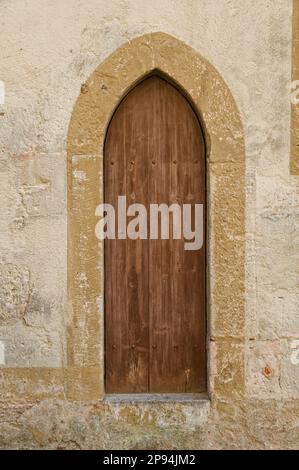 Ein alter Holzfensterladen eines weißen Steingebäudes auf dem Land Stockfoto