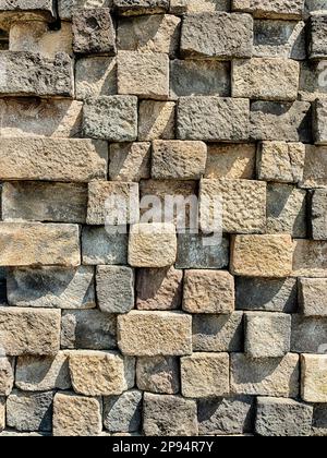 Eine Steinmauer aus Blöcken ist Teil der Gründung des buddhistischen Tempels Borobudur in der Nähe von Yogyakarta, Indonesien. Stockfoto