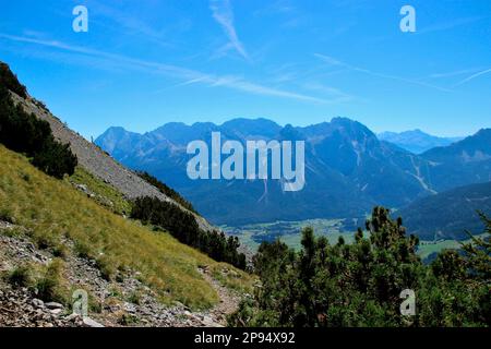 Blick während des Abstiegs vom Gipfel des Daniel (2340m), dem höchsten Gipfel der Ammergaualpen, auf die Mieminger Bergkette mit dem prominenten Gipfel der Sonnenspitze (2417m), Lermoos, Zugspitzarena, Tirol, Österreich Stockfoto