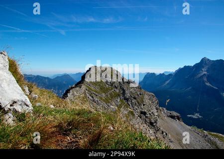 Blick vom Gipfel der Upsspitze (2332m) auf den benachbarten Gipfel Daniel (2340m), den höchsten Gipfel der Ammergaualpen, Lermoos, Zugspitzarena, Tirol, Österreich Stockfoto