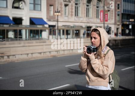 Ein junges Touristenmädchen in der amerikanischen Stadt Chicago, das Fotos mit einer klassischen Fotokamera macht Stockfoto