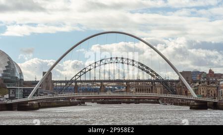 Blick auf die Brücken über den Fluss Tyne, einschließlich der Gateshead Millennium Bridge und Tyne Bridge, vom Quayside, Newcastle Upon Tyne, Großbritannien. Stockfoto