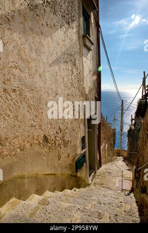 Von Agerola nach Amalfi ist ein steiler Pfad mit Tausenden von Stufen, die sich die Hügel der Küste hinunter in Richtung Amalfi schlängeln. Blick auf das Meer und die Küste. Von Agerola nach Amalfi ist ein steiler Pfad mit Tausenden Stufen, die sich die Hügel entlang der Küste in Richtung Amalfi hinunter schlängeln. Blick auf das Meer und die Küste. Treppenstufen auf dem Weg zur Küste. Stockfoto