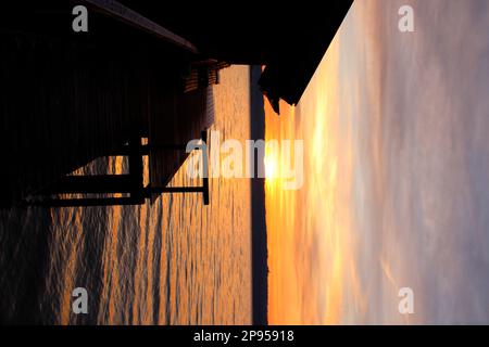 Bootshaus bei Sonnenaufgang am Seeufer, Holzhausen, Ammersee, Voralpensee, Alpenvorland, Oberbayern, Bayern, Deutschland Stockfoto