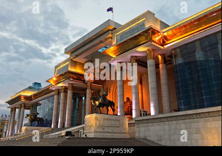 Parlamentsgebäude auf dem Platz Süchbaatar mit Dschingis-Khan-Denkmal bei Nacht, Ulaanbaatar, Mongolei Stockfoto