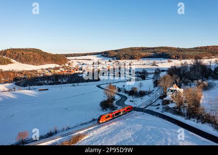 Deutschland, Thüringen, Bechstedt (Hintergrund), Regionalzug 60, Zug 29887, Halt Bechstedt-Trippstein, Haus (ehemaliges Empfangsgebäude), Landschaft, Dorf, Felder, Wälder, Schnee, Übersicht, Abendlicht Stockfoto