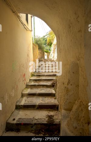 Steintreppen auf einem Pfad, der von Agerola zum Küstenstreifen von Amalfi führt. Bogengang durch Gebäude beim Abstieg. Wandern an der Amalfiküste. Salerno, Italien Stockfoto