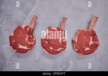 Aufnahme von Tomahawk Beef Steaks über Kopf im Hintergrund in Butcher's Shop Display Stockfoto