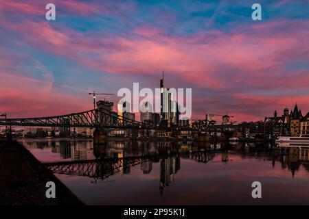 Blick über den Main bis zur Skyline von Frankfurt am Main. Sonnenuntergang hinter den Wolkenkratzern des Bankenviertels Stockfoto