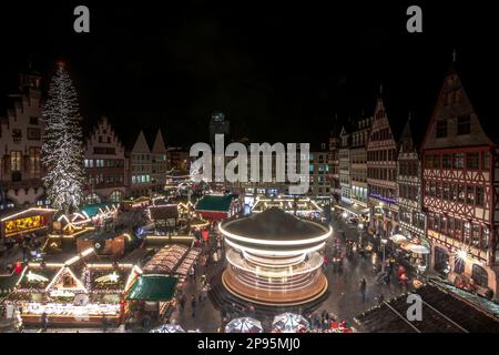 Weihnachtsmarkt am Abend, wunderschön beleuchtetes Festival auf dem Römerberg in Frankfurt am Main, historisches Ambiente mit Fachwerkhäusern und romantischer Atmosphäre. Weihnachtstradition in Hessen Stockfoto