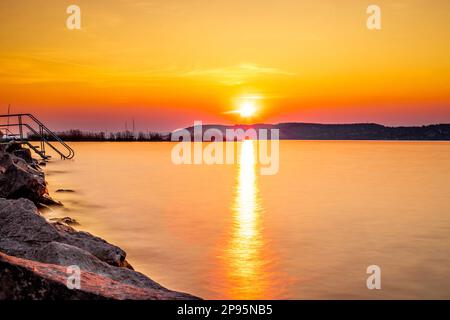 Sonnenuntergang am Balaton, Plattensee in Ungarn, romantischer Blick auf den Sonnenuntergang über dem See Stockfoto